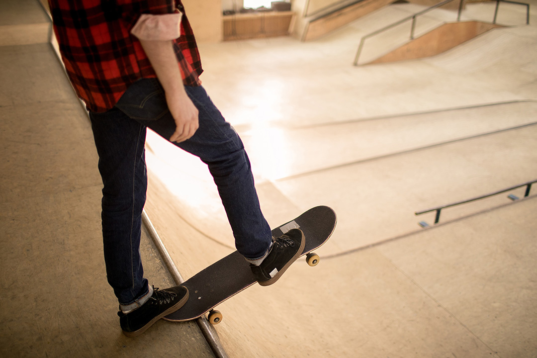 a skateboarder about to do a stunt from the edge of a skatepark