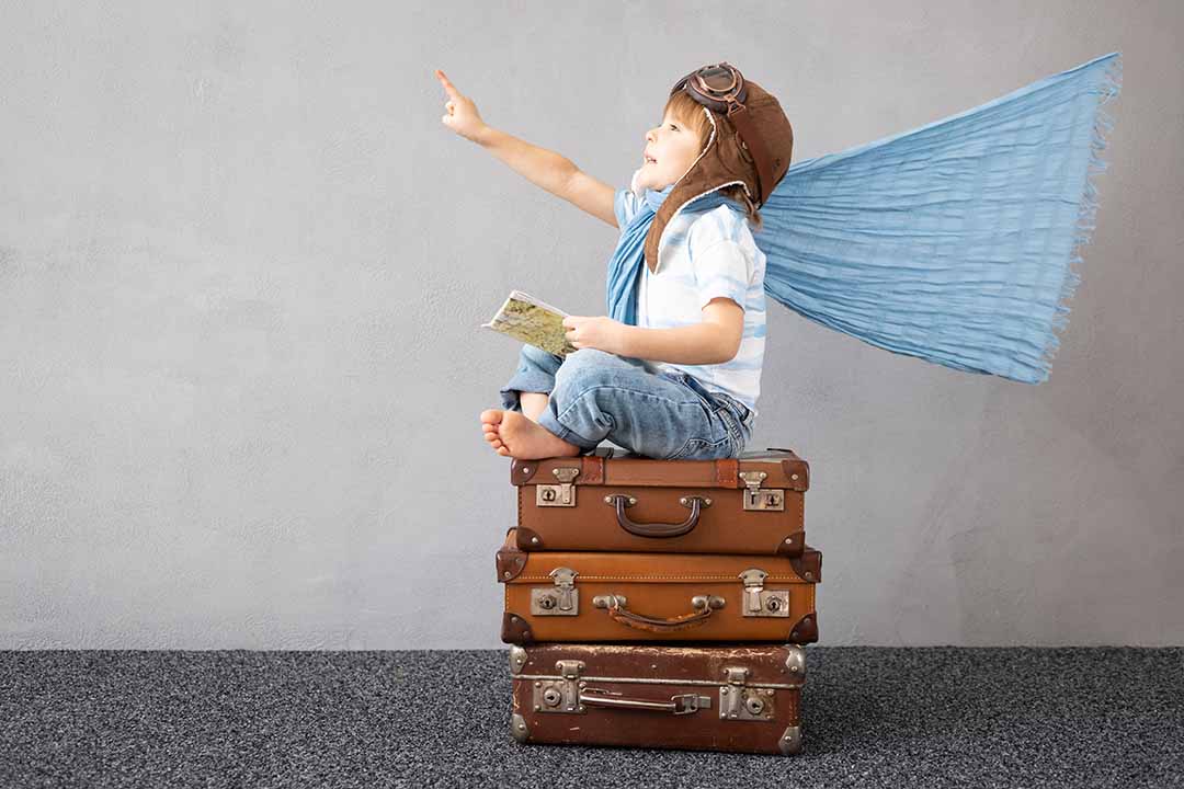 child sitting on suitcases, imaging