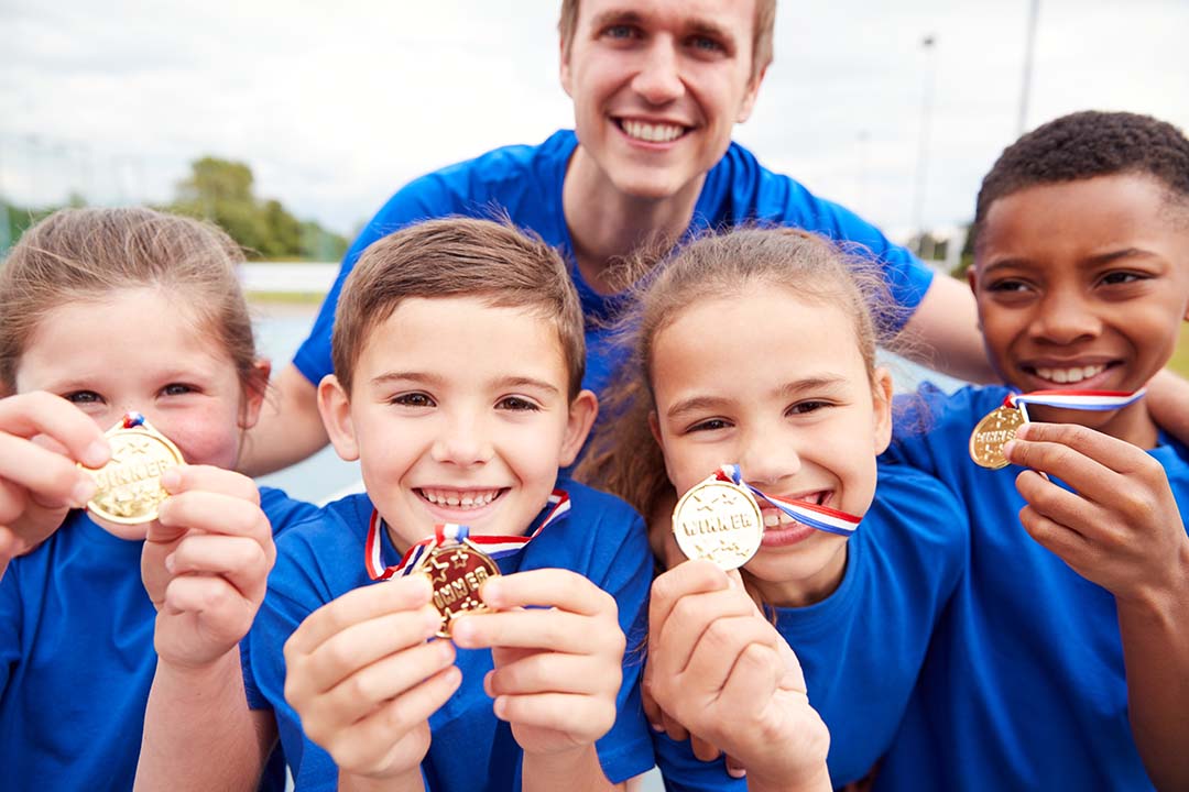 children holding up winner medals