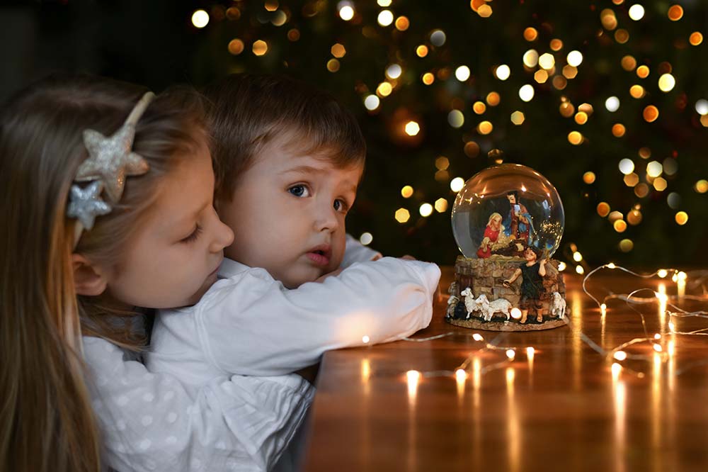 children looking at a nativity scene in a glass ball