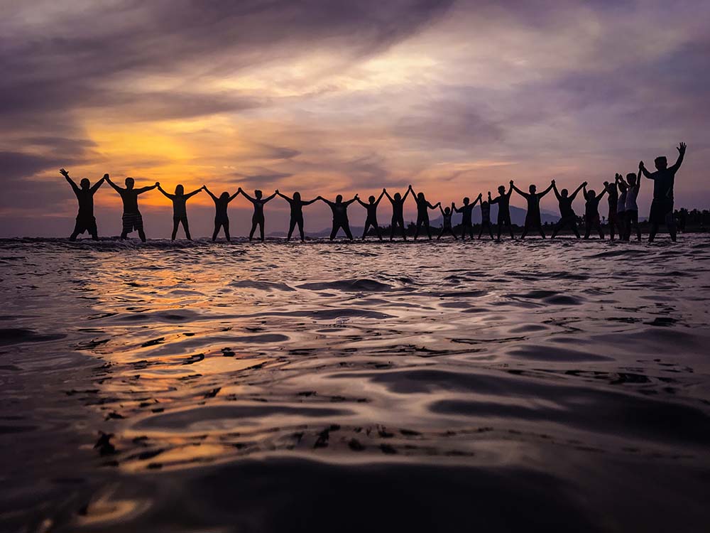 people standing in unity at sunset