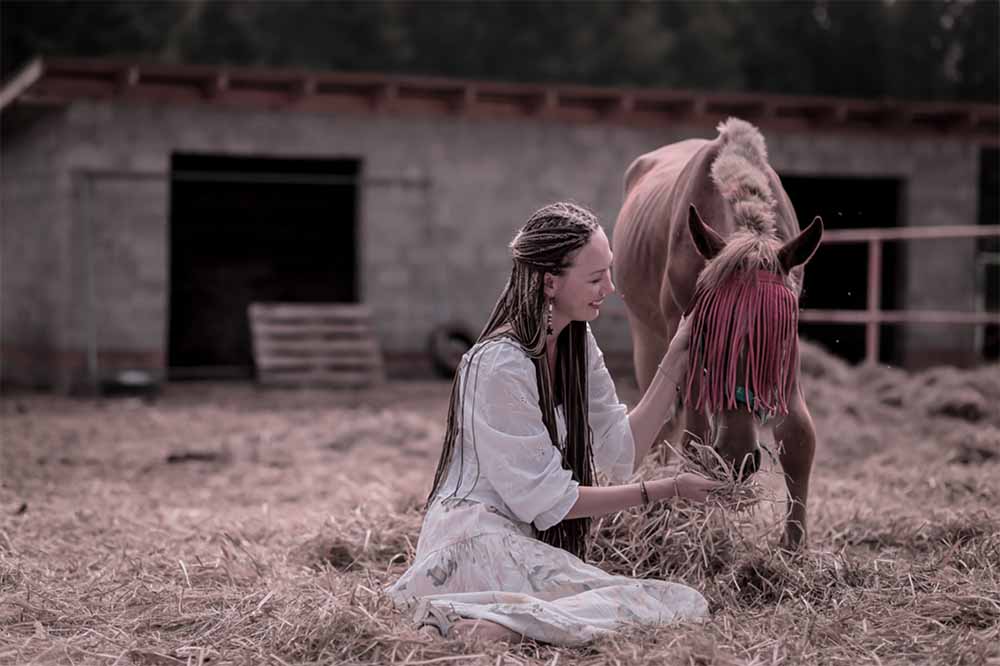 woman tending to a horse on a farm